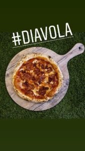 Pizza Diavola artesanal elaborada con mozzarella fundida, salami picante y salsa de tomate sobre masa tradicional italiana.