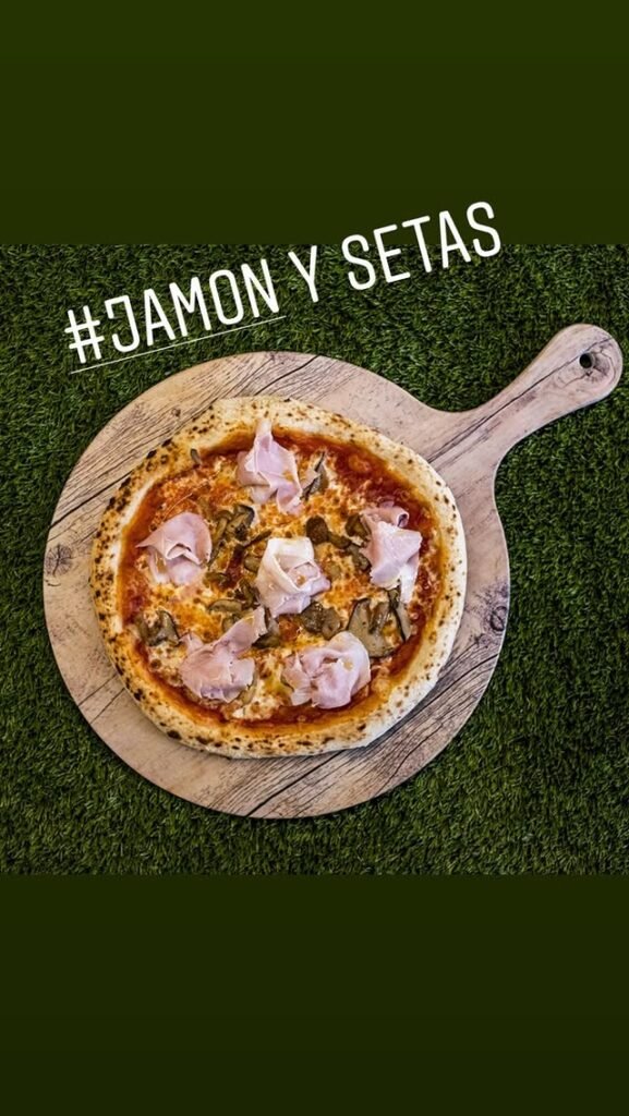 Pizza de jamón y setas frescas.